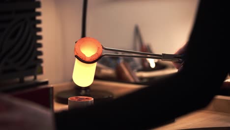 slow motion shot of a jeweller pouring molten silver from a furnace into a mould to be used in jewellery