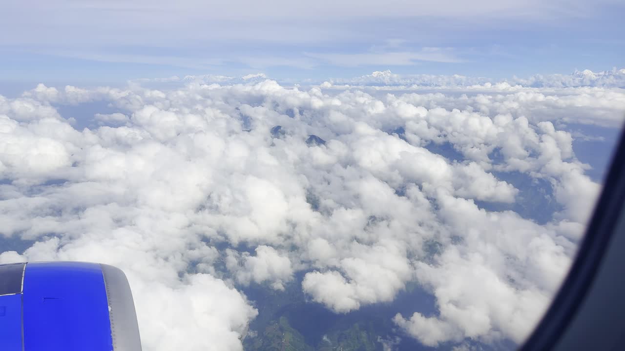 Footage showing clouds in the sky as seen from an airplane window, capturing aerial atmospheric views, soft white formations, and a serene blue horizon, ideal for travel, aviation, and nature visuals