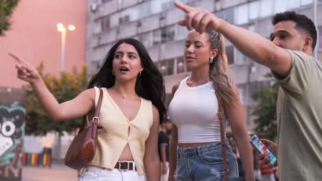 women asking help from man using smartphone on city street