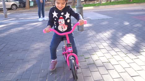 young girl kid learning to ride her bike for the first time in slow motion