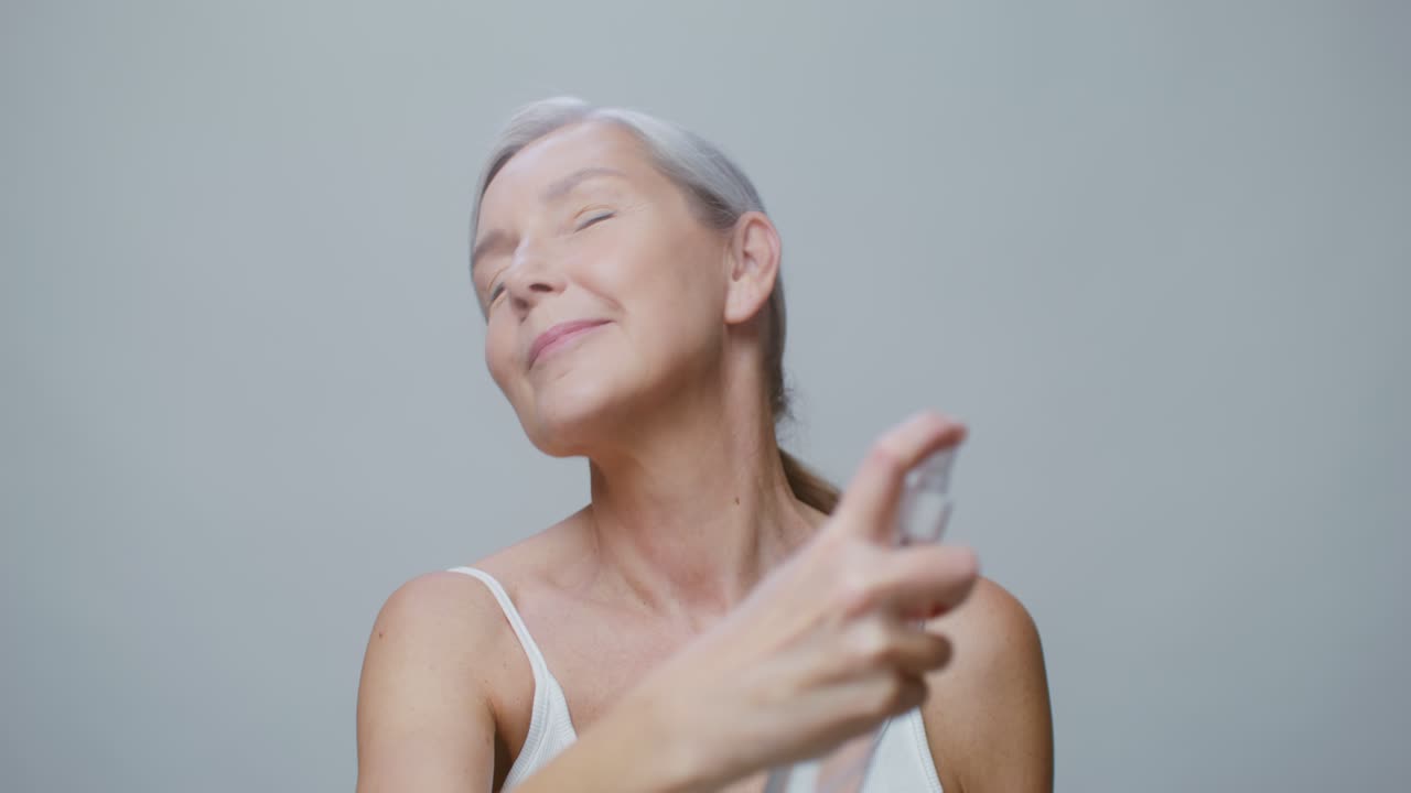 Mujer mayor aplicando spray facial
