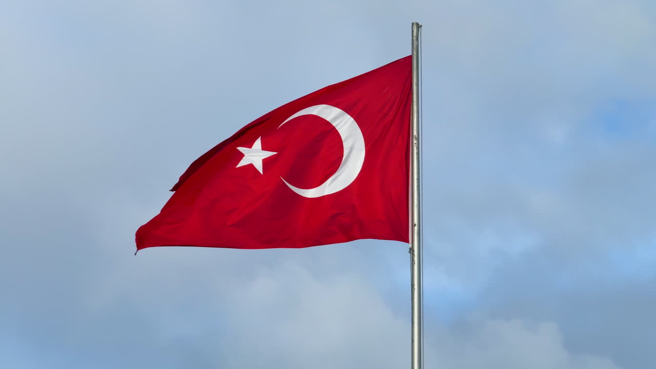 Det tyrkiske nationalflag vajer mod himlen i Istanbul og symboliserer national identitet og stolthed. Koncept om patriotisme, suverænitet og landesymbolik. Tyrkiet. UHD