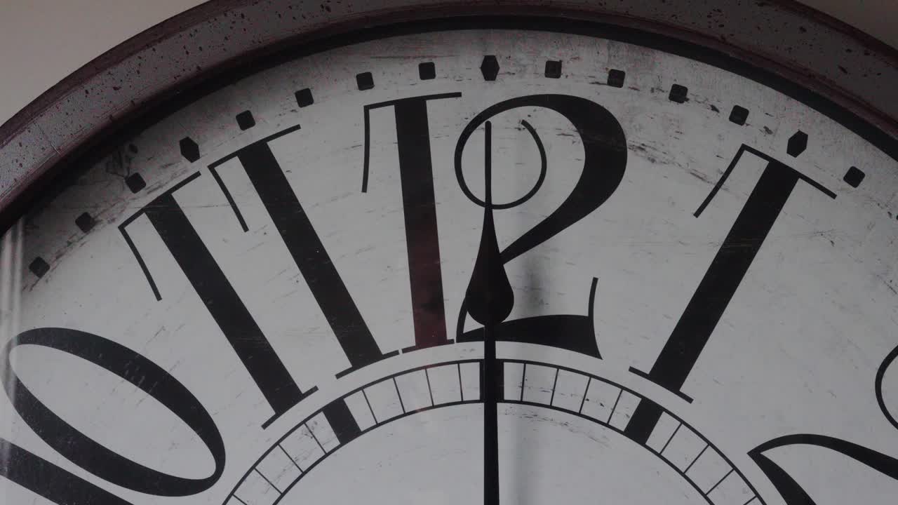 Close up of clock minute hand ticking to noon or midnight