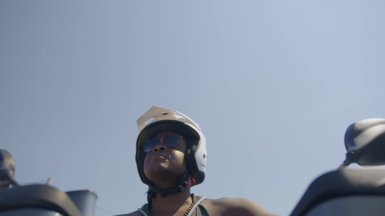 hombre negro conduciendo una motocicleta en la calle, policía de playa, aplicación de la ley, pobreza, 4k | mirando a su alrededor, tembloroso, carretera, viaje, en persecución