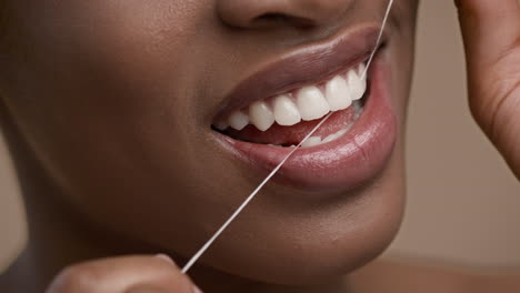 mujer lavándose los dientes con hilo dental