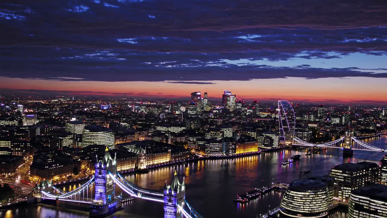 Aerial video view of London at dusk, showcasing illuminated landmarks and the Thames