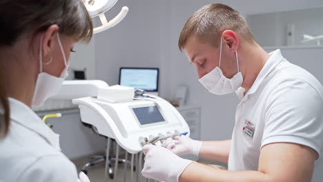 medica dental care for a patient in modern stomatology clinics. male dentist and female nurse discuss and comment during their work.