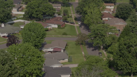 drone flyover ranch houses in suburbs towards a bus driving across the frame