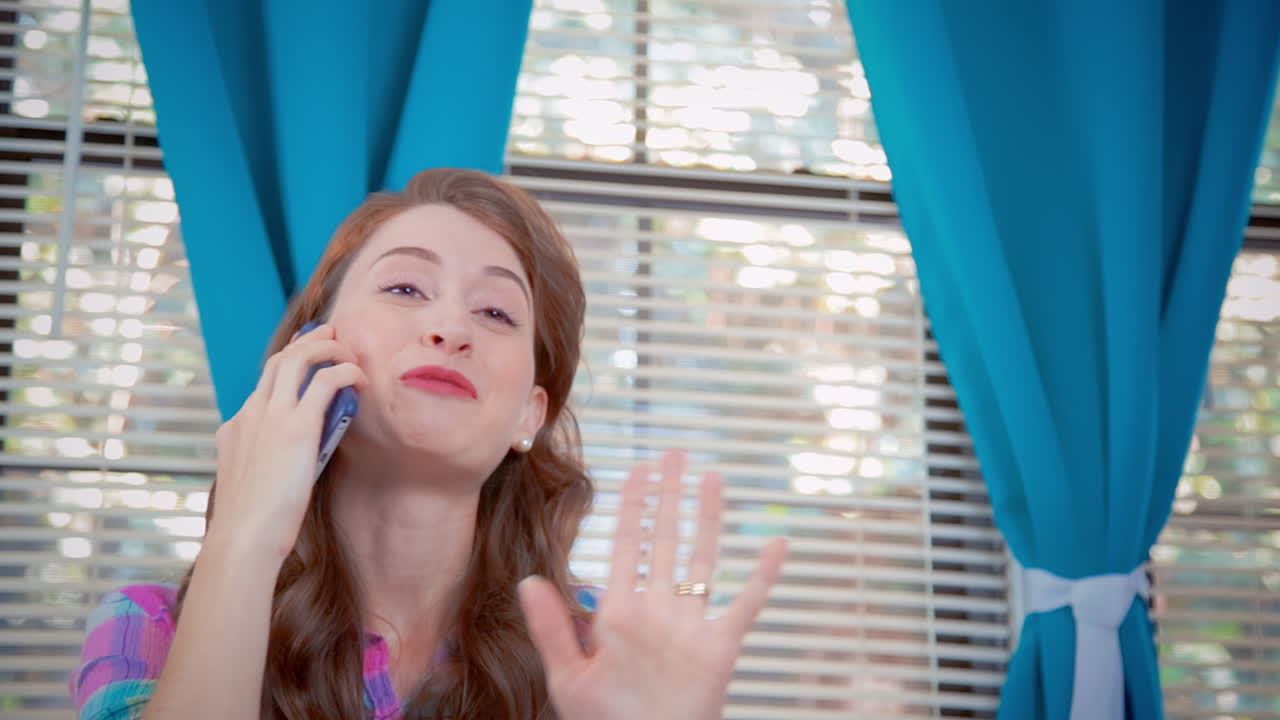 젊은 백인 여성 이  ⁇ 드폰 으로 이야기 하고 있습니다. 그 여자 는 흥분 하여 놀라운 이야기 를 묘사 합니다.