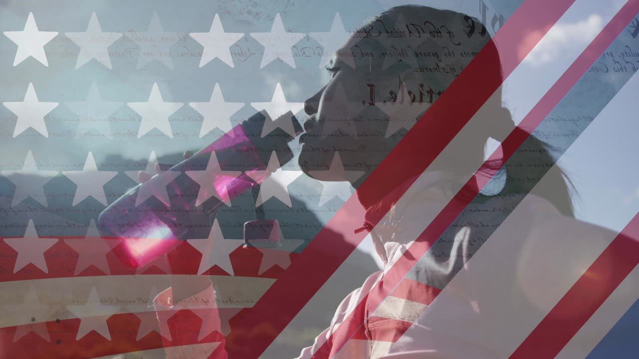 animación de la bandera estadounidense sobre una mujer biracial bebiendo agua en las montañas