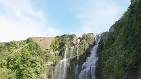 ogawa waterfall plunging over rocky edge in kagoshima japan, copy space in sky