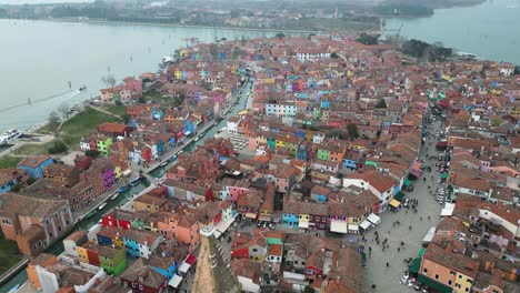 aerial view of panorama of painted house facades of burano, island province of venice in italy on a foggy day