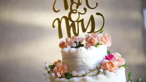 Smooth-shot-of-a-beautifully-decorated-wedding-cake-on-a-fancy-platter-at-a-wedding-reception