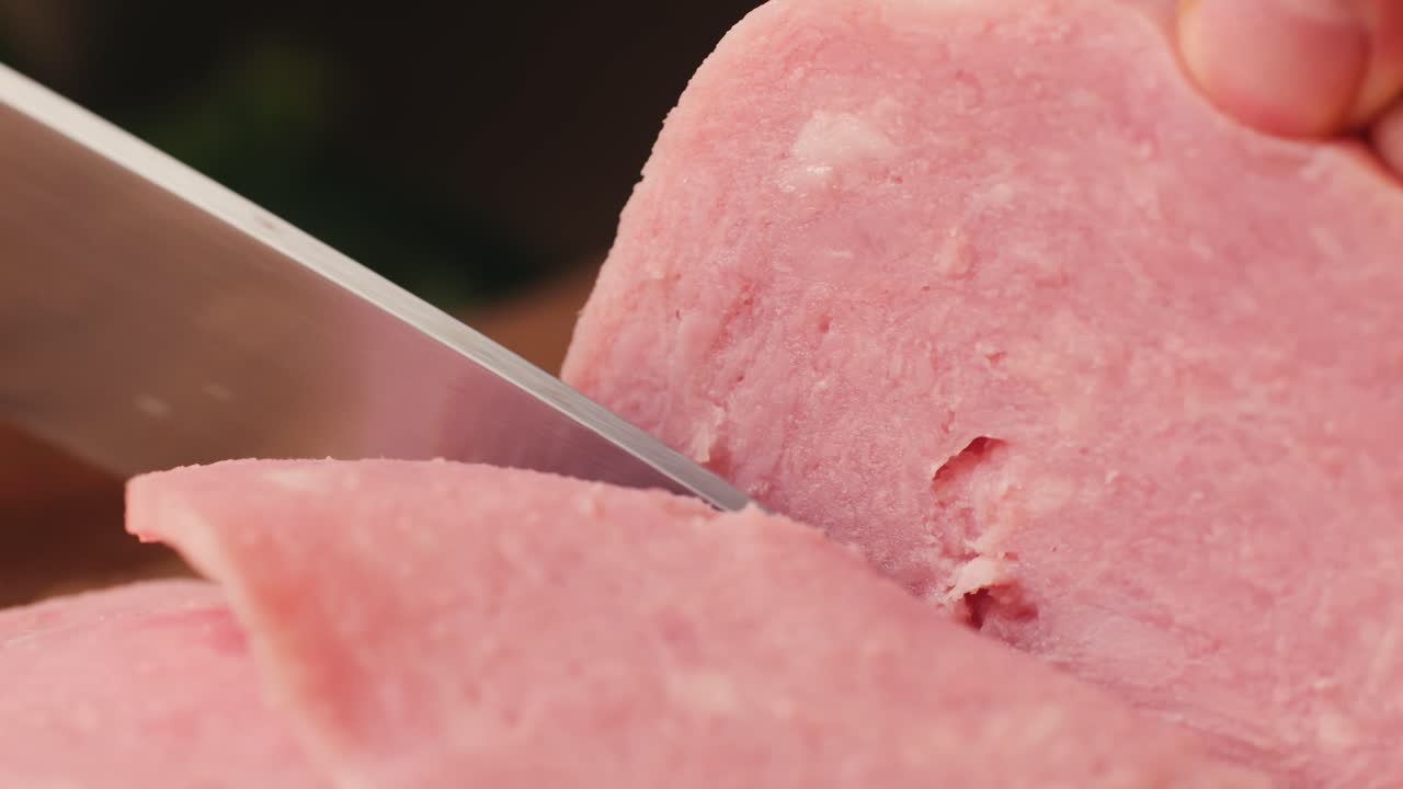 Ham italian mordatella, man Slices Of Traditional Italian antipasti mortadella sausage on a wooden cutting board, close up macro of chicken or turkey jamon, fat breakfast dish.