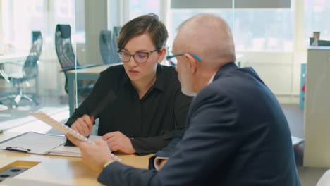 colleagues discussing papers on business meeting