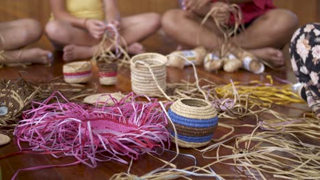 círculo de mujeres tejiendo cestas maoríes tradicionales