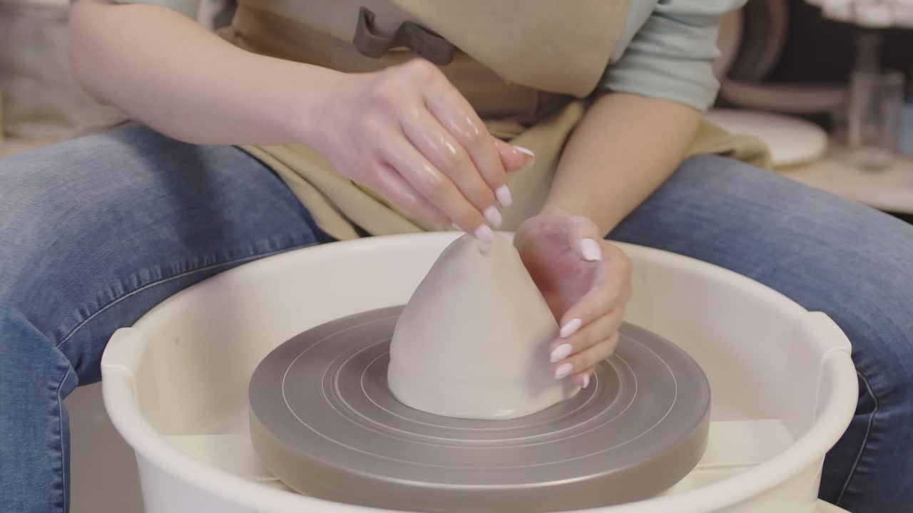 mujer irreconocible trabajando en la rueda del alfarero