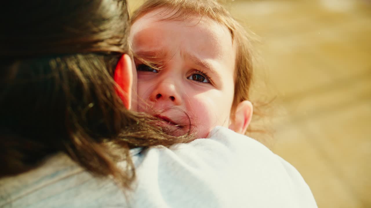 Un tenero momento tra un caregiver e un bambino, che mette in mostra amore, fiducia e connessione mentre si scambiano un abbraccio sincero in un sereno ambiente esterno
