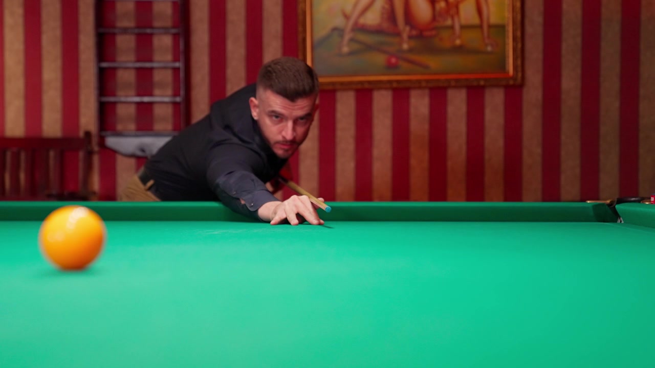 Man stoot speelbal tijdens biljarten in slow motion