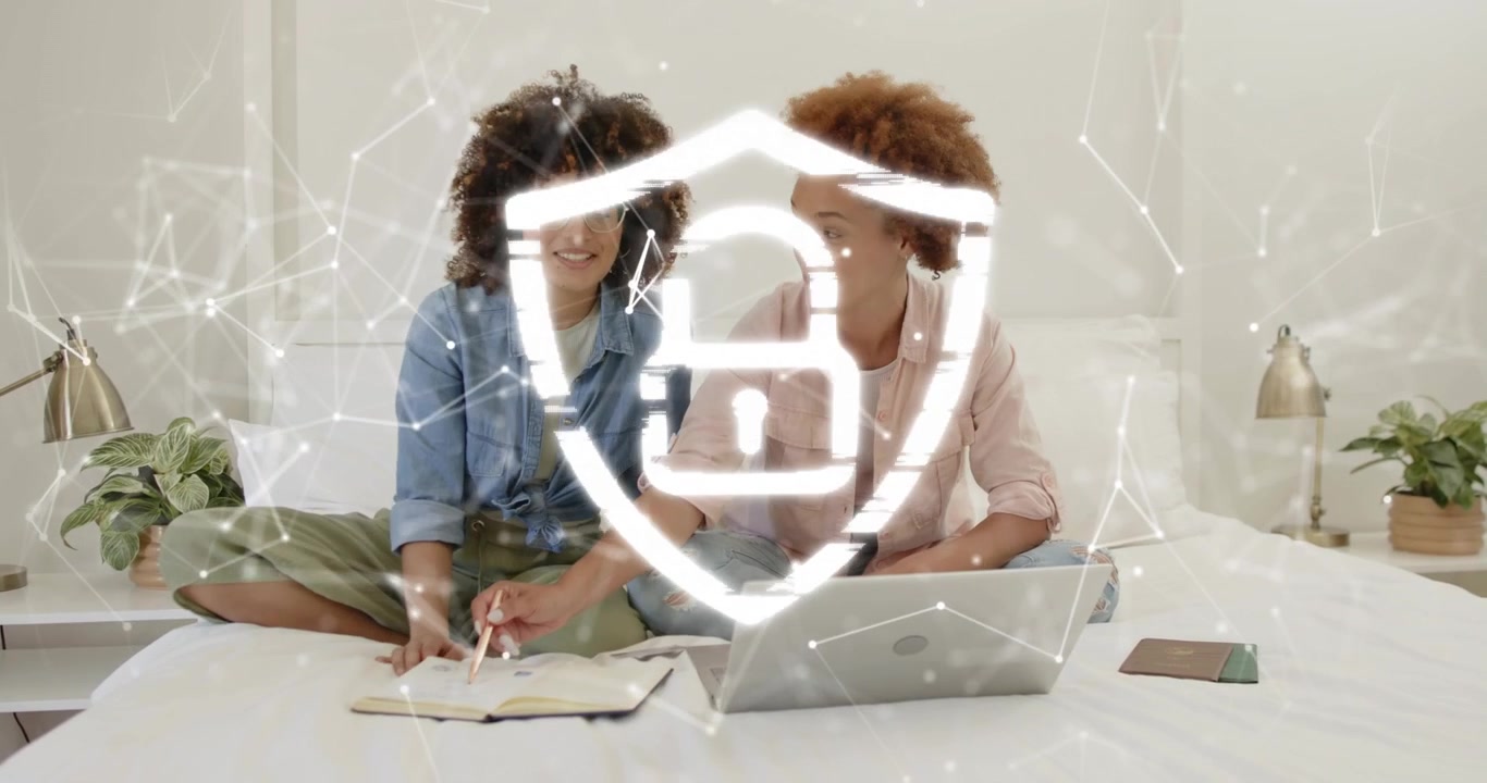 Two women consulting notes, swirling shield typing on laptop while lines fading for study session