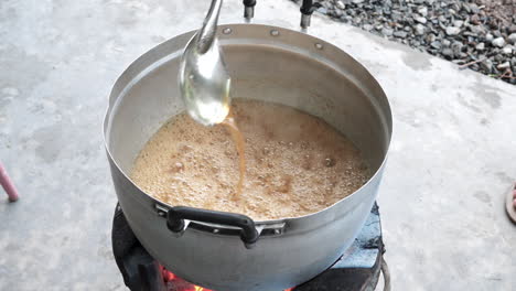 Top-view-outdoor-kitchen,-chef-mixes-boiling-tamarind-sauce---Thailand-dish