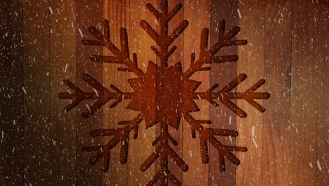 Animation-of-christmas-snowflake-decoration-with-snow-falling-on-wood