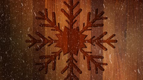 animation of christmas snowflake decoration with snow falling on wood