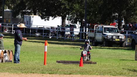 child practices riding motorcycle with guidance