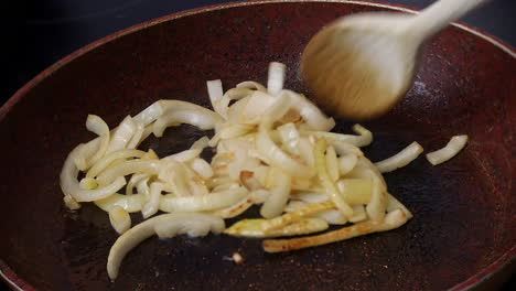 onions are fried in a frying pan in oil