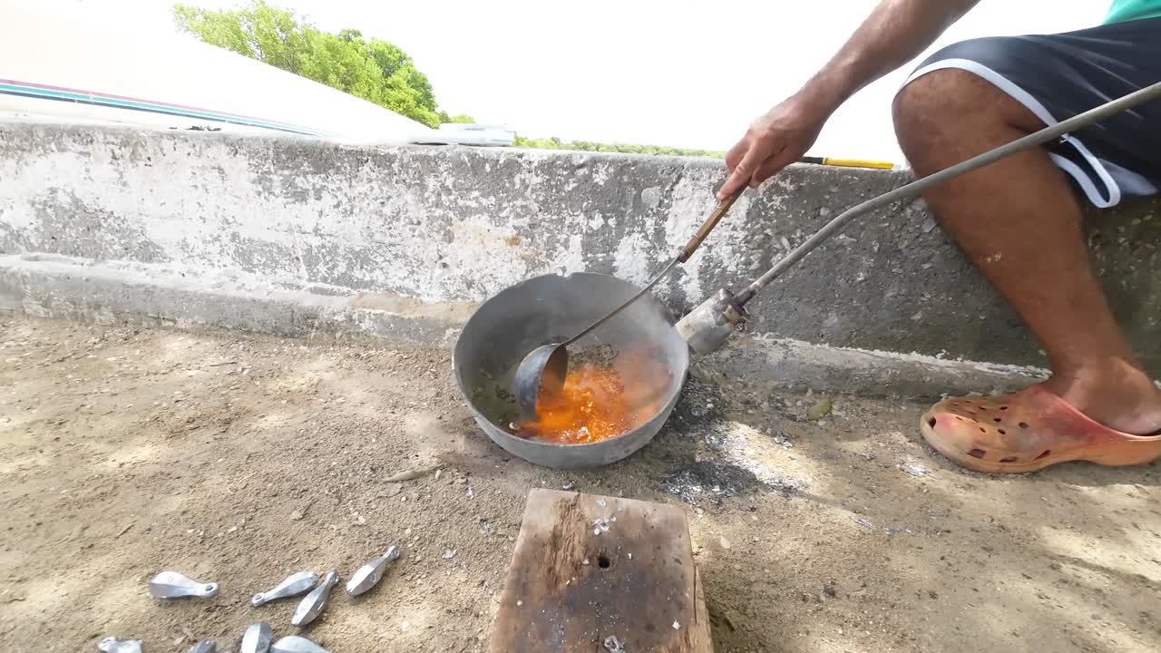 hombre que fundió plomo fundido en un molde al aire libre con cuchara, proceso tradicional de metalurgia, día soleado