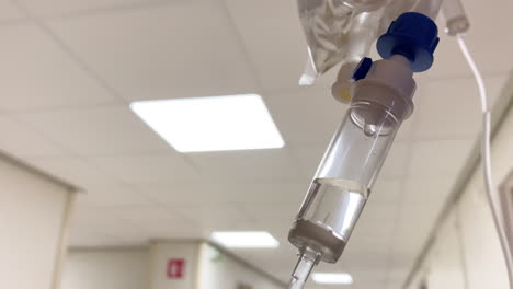 close up of an intravenous drip with soft focus hospital background