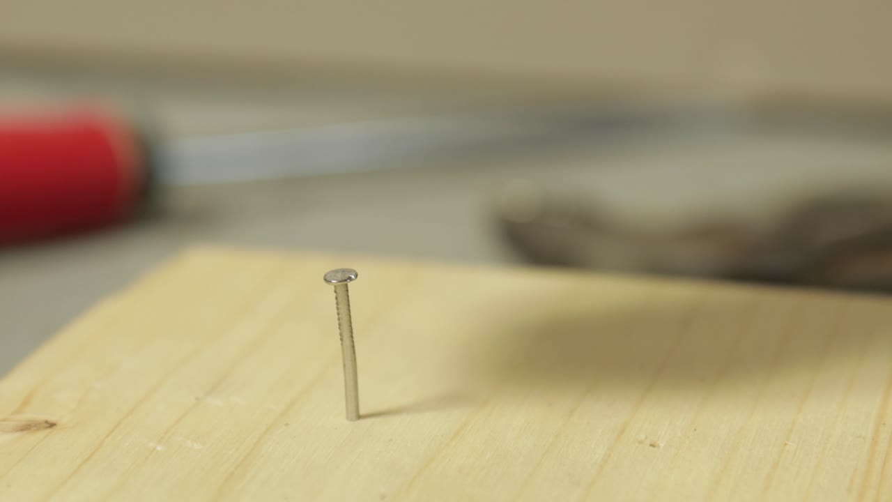 trabajador martillando clavos en un tablón de madera detalle de primer plano todavía