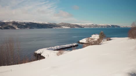 view of a cabin on the snow-covered shore of trondheimsfjord, trondheim, norway