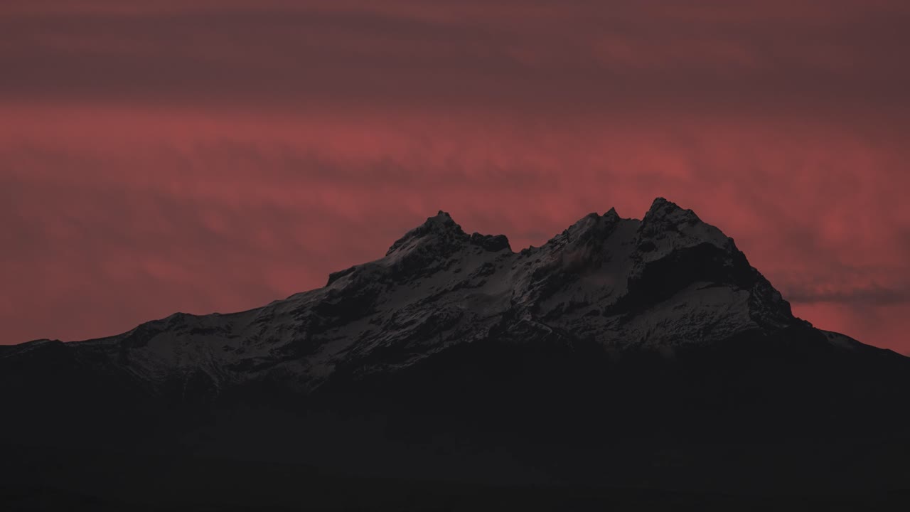 Time-lapse capturing Carihuairazo’s snowy summit as the sky reddens and fades to night. Experience the Andes’ majestic transition from dusk to darkness.