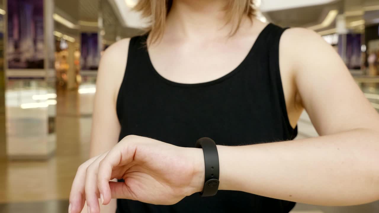 una chica joven presiona en un bracelet de concepto de interfaz de usuario futurista. interfaz de usuario gráfica - gui. pantalla de cabeza hacia arriba - hud. internet de las cosas.
