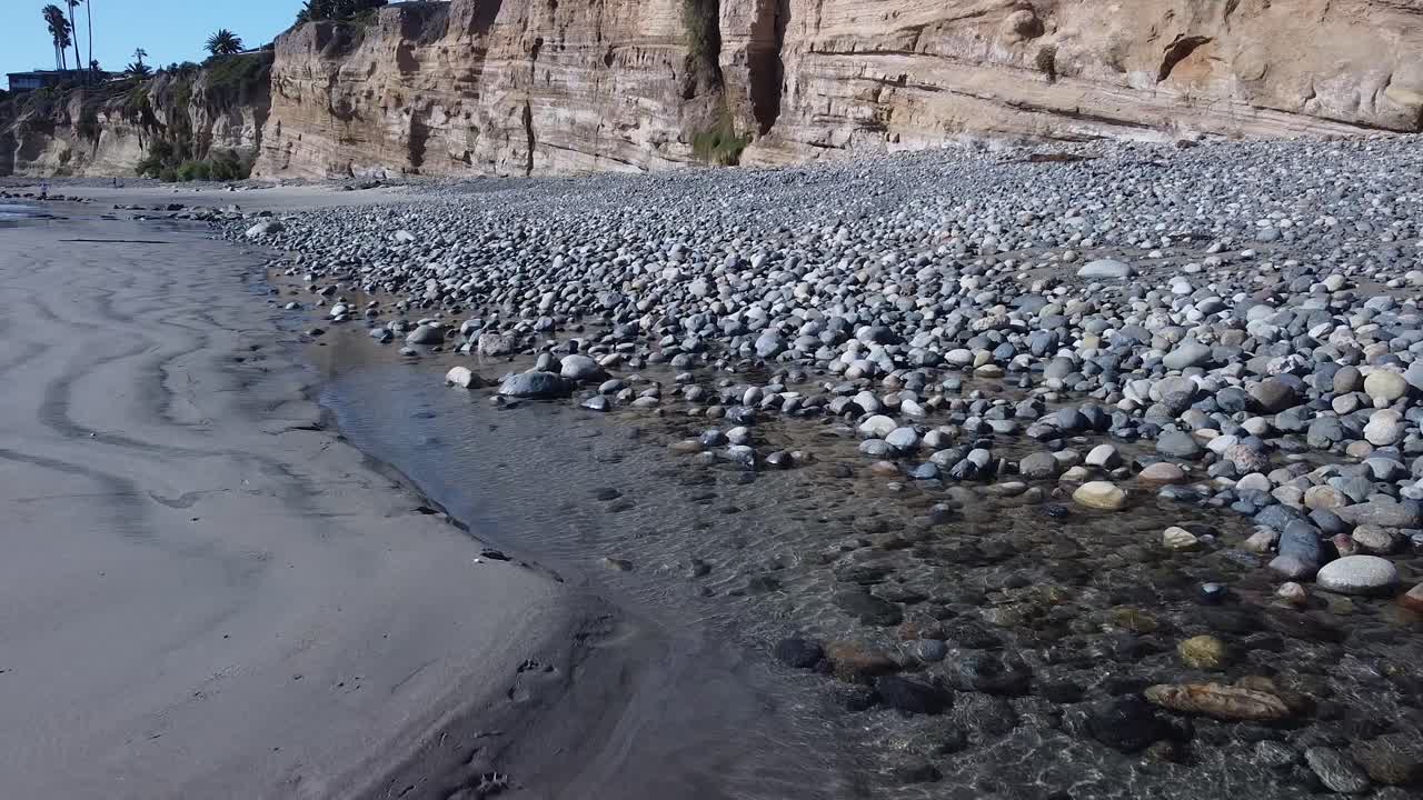 volando cerca de las rocas en la playa