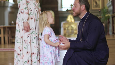 priest talking with little child