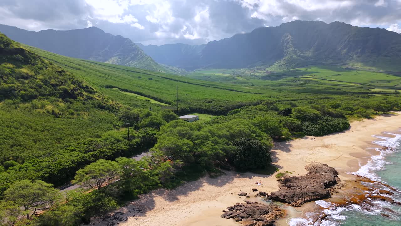 La lussureggiante Valle di Makua e le montagne Waianae con una spiaggia a Oahu, ripresa aerea con allontanamento.