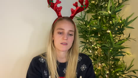 jeune femme en appel vidéo de noël à l'air visiblement déprimée et parlant à la caméra