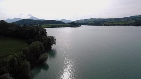 Flight-Next-To-The-Coast-Above-Nature,-Lake-Gruyère,-Switzerland