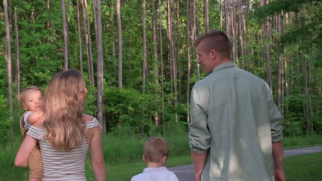 family walking in woods holding hands surrounded by lush greenery a heartwarming video of a family peacefully walking in beautiful woods holding hands surrounded by greenery and trees showing their strong bond