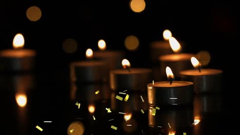 Animation-of-gold-confetti-falling-over-lit-tea-light-candles-with-bokeh-lights-and-dark-background