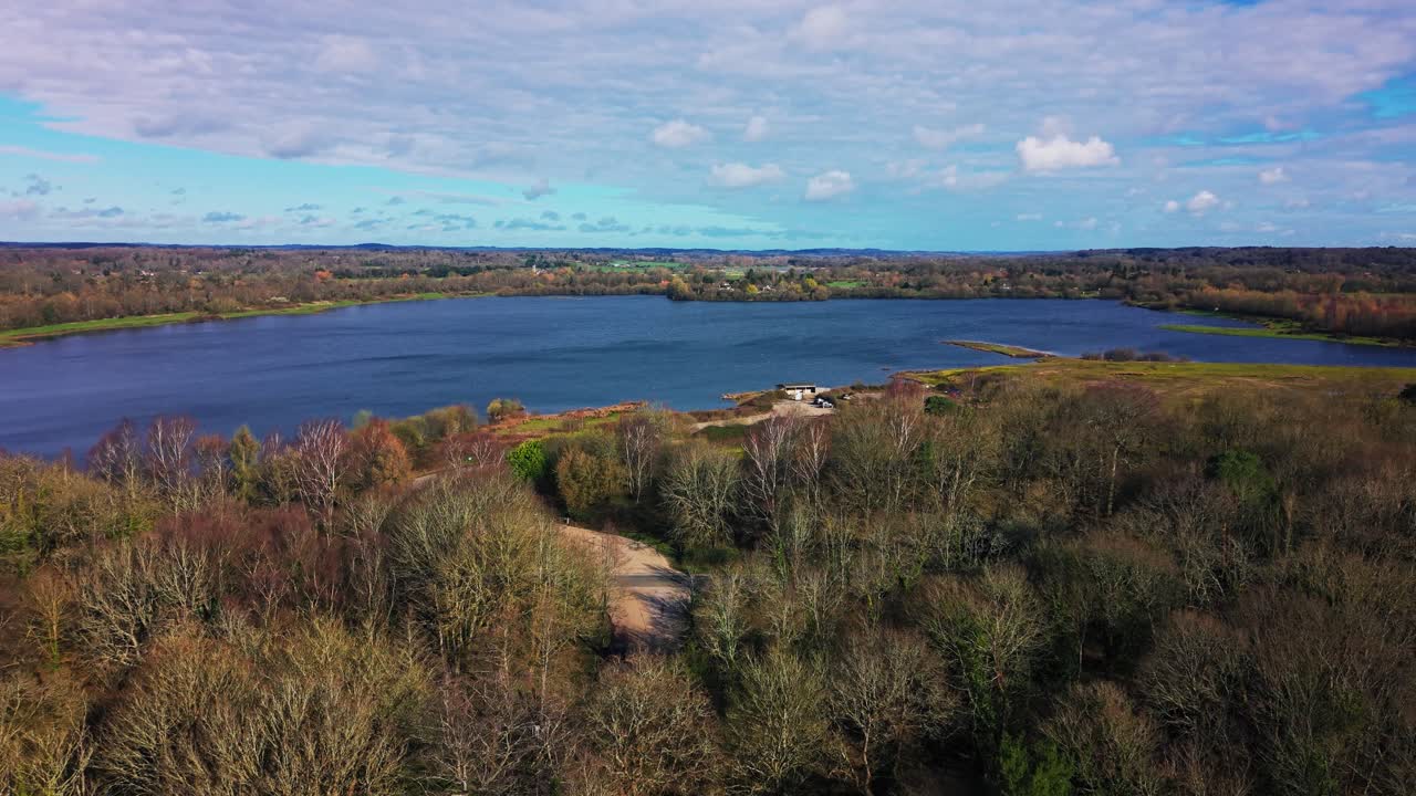 Droneudsigt over Blashford Lakes, der viser roligt vand, omkringliggende skovområde og naturligt landskab i det engelske landskab.
