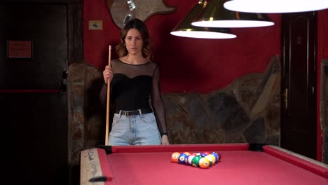 Woman-standing-with-cue-near-billiard-table