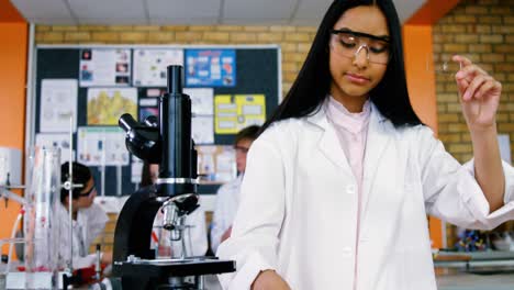 Niña-De-La-Escuela-Escribiendo-En-Un-Libro-De-Diario-Mientras-Experimenta-En-El-Laboratorio