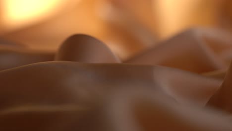 close up shot of silk textiles used in the fashion industry backlit by studio lighting.