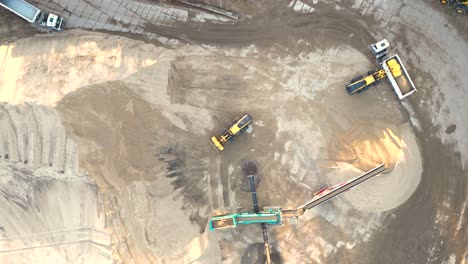 Mining-truck-transporting-sand-at-sand-quarry-aerial-view-of-mining-machinery-moving-at-sand-mine-top-view-of-mining-equipment-at-sand-mine-mining-industry-heavy-vehicle-at-sandpit