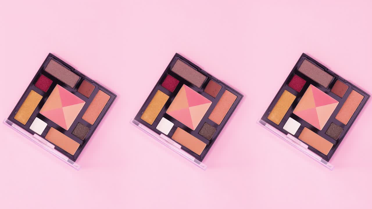 Three eye shadow palettes with pastel colors rotate on bright pink theme. Stop motion