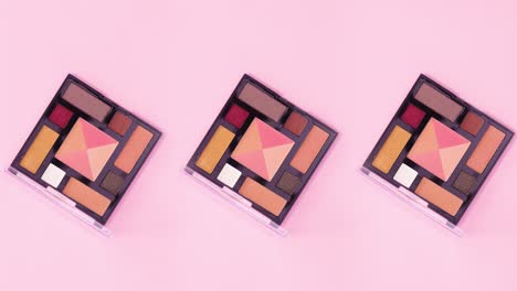 three eye shadow palettes with pastel colors rotate on bright pink theme. stop motion