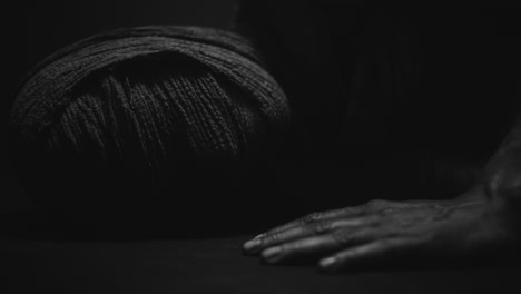 a mummy of a woman on a dark backdrop quickly rises her head